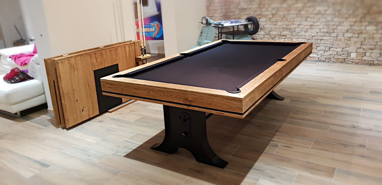 Le plateau de table finition chêne brossé huilé en 3 parties se dépose aisément pour laisser place au tissu de jeu de billard noir. Cet ensemble est une création de la marque de billard américain Eurobillards